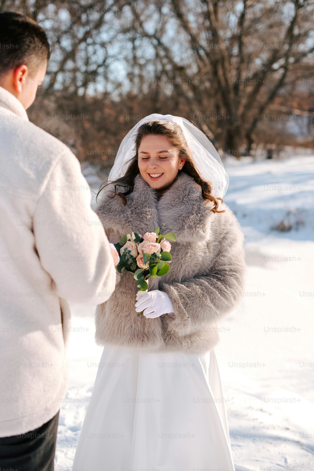 une mariée et un marié debout dans la neige
