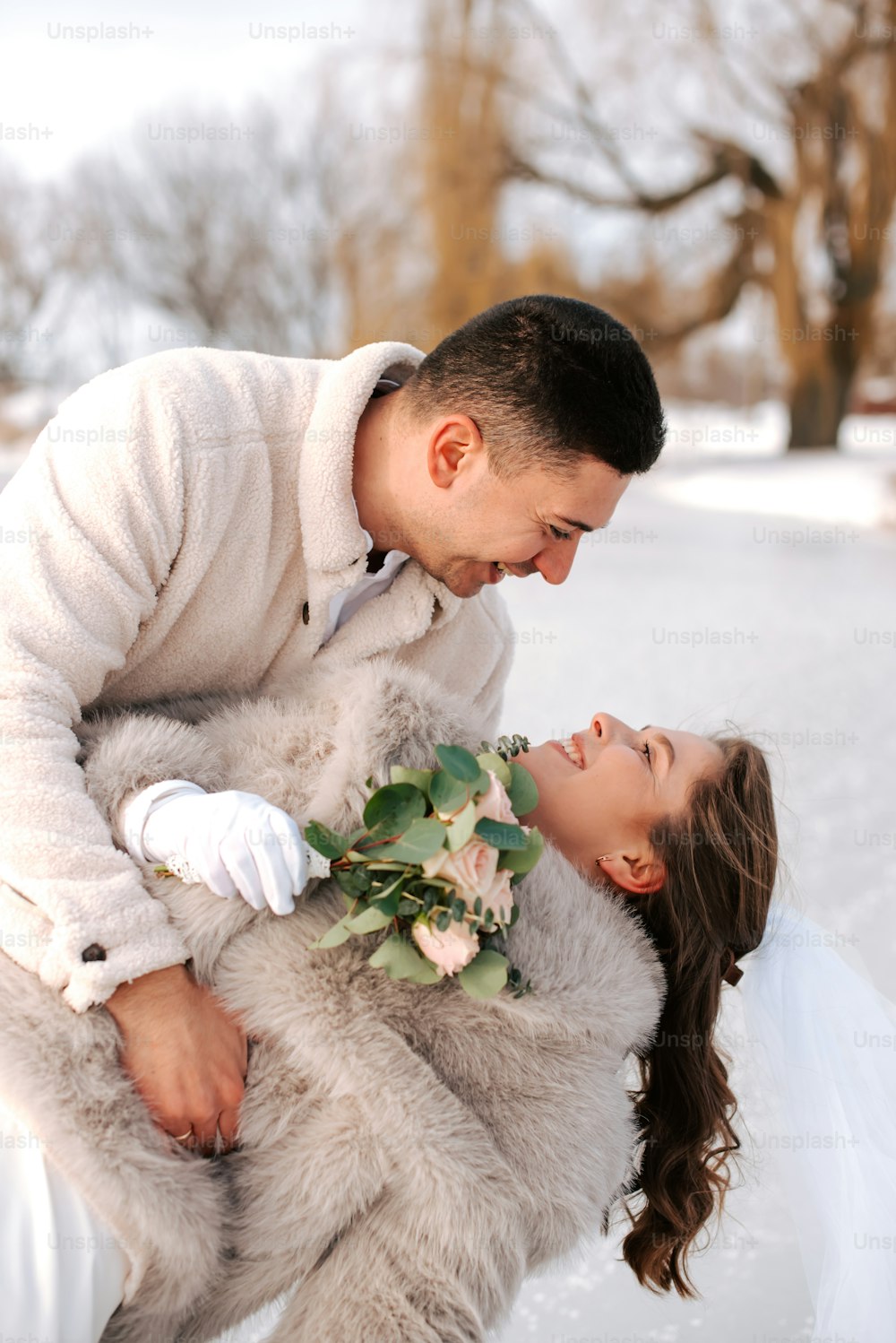 un homme tenant une femme sur son dos dans la neige