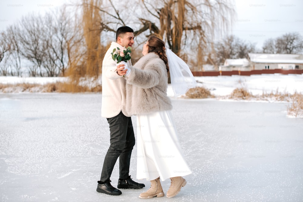 a bride and groom are standing in the snow