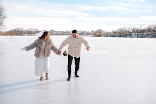 a man and a woman holding hands on a frozen lake