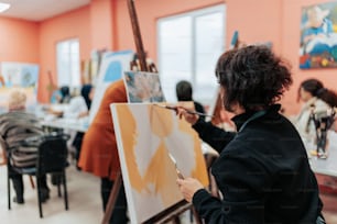 uma mulher está pintando em uma aula de arte