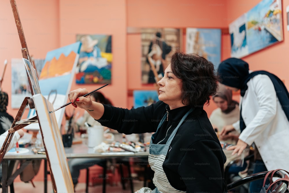 a woman is painting in an art class