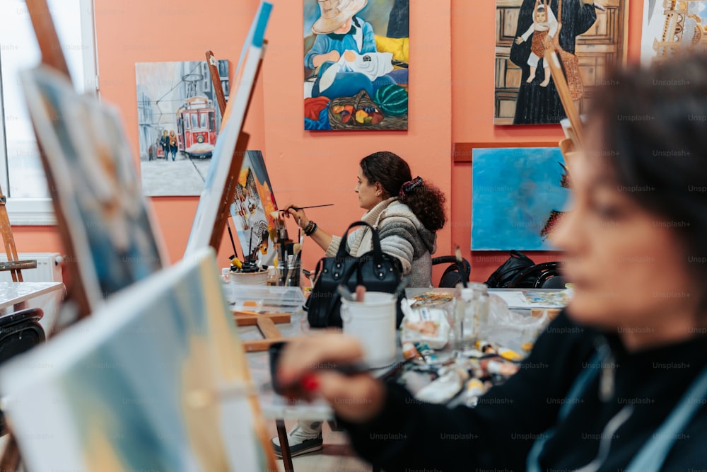 a woman sitting at a table in front of a painting