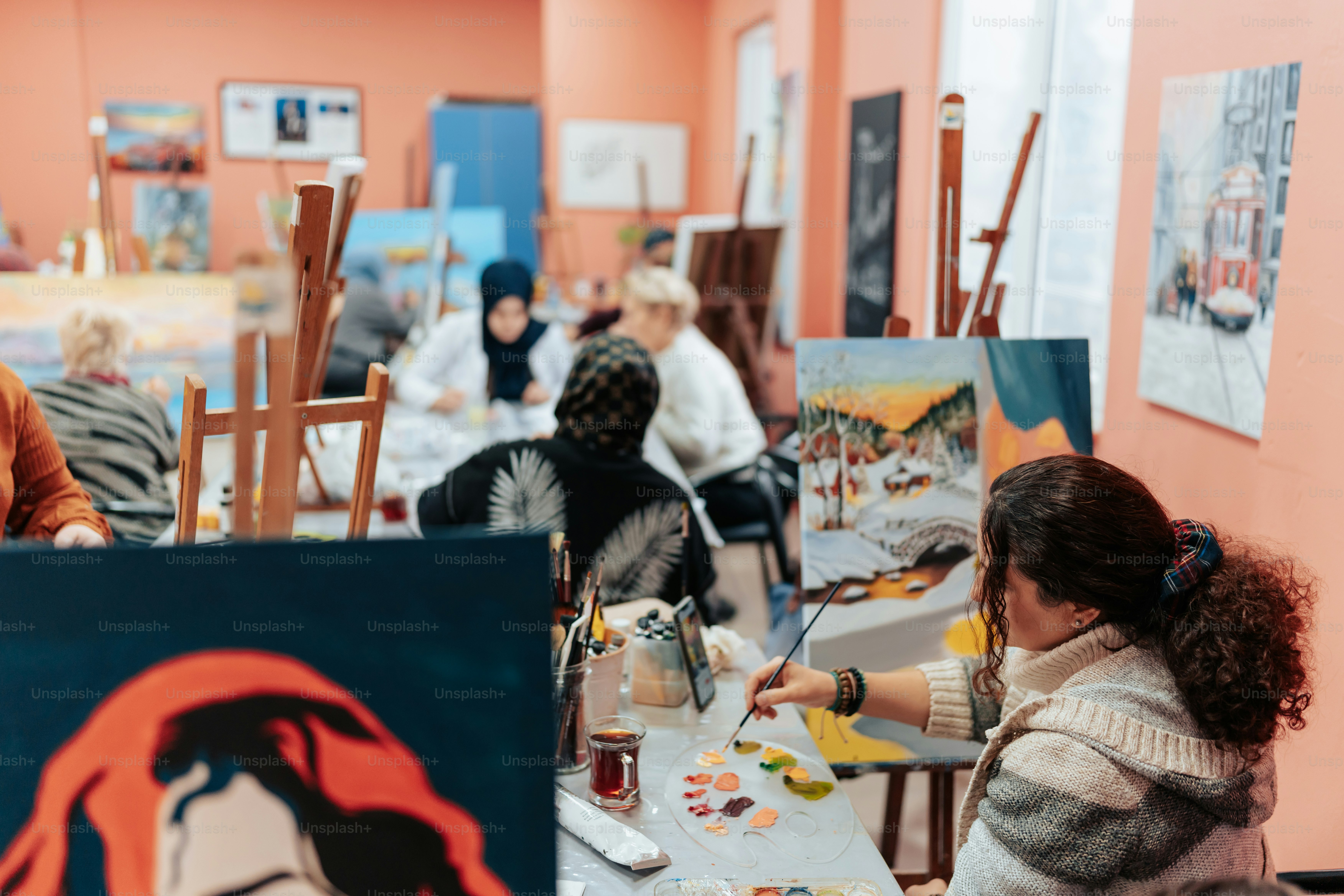 un groupe de personnes assises autour d’une table en train de peindre