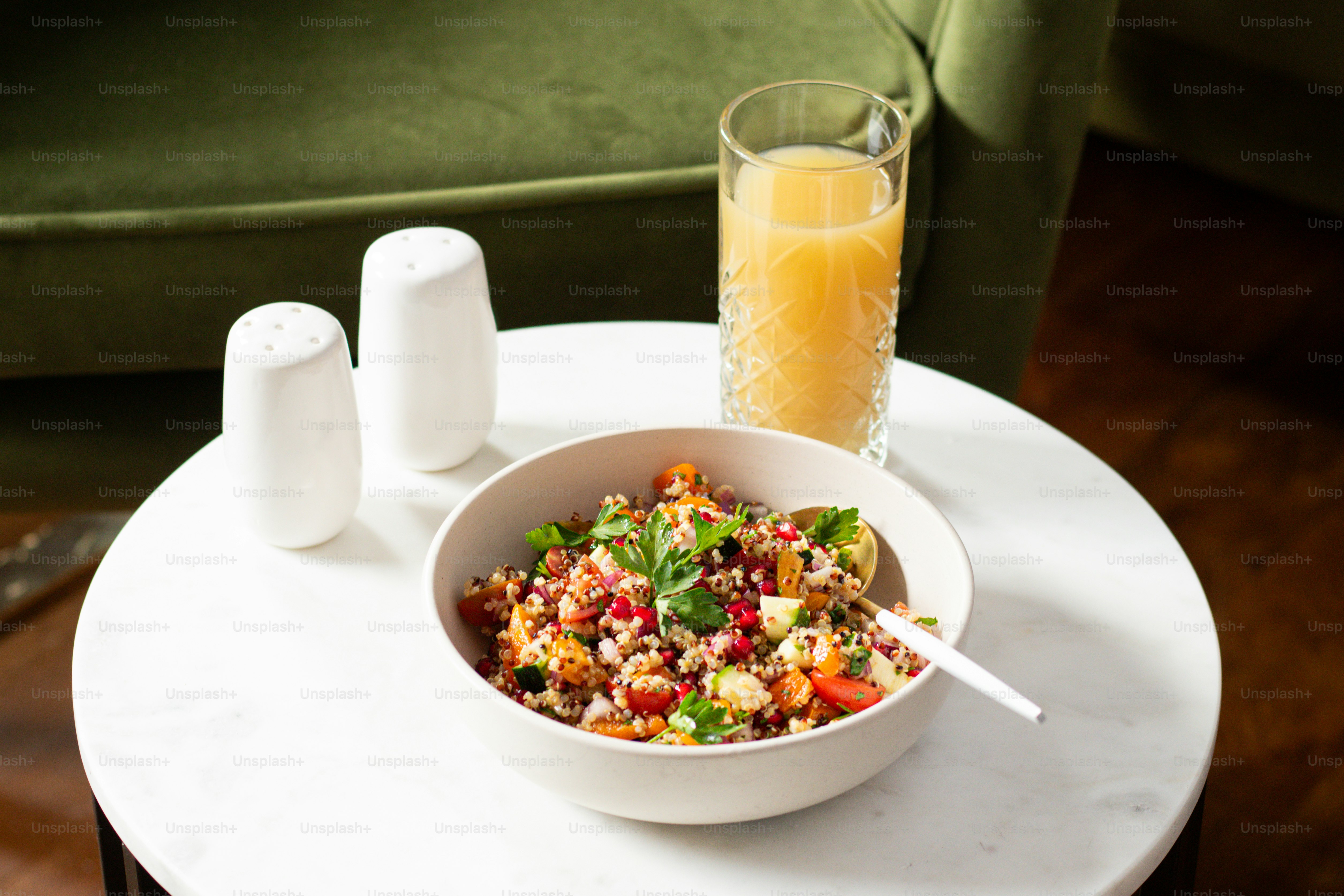 a bowl of food sitting on a table next to a glass of orange juice