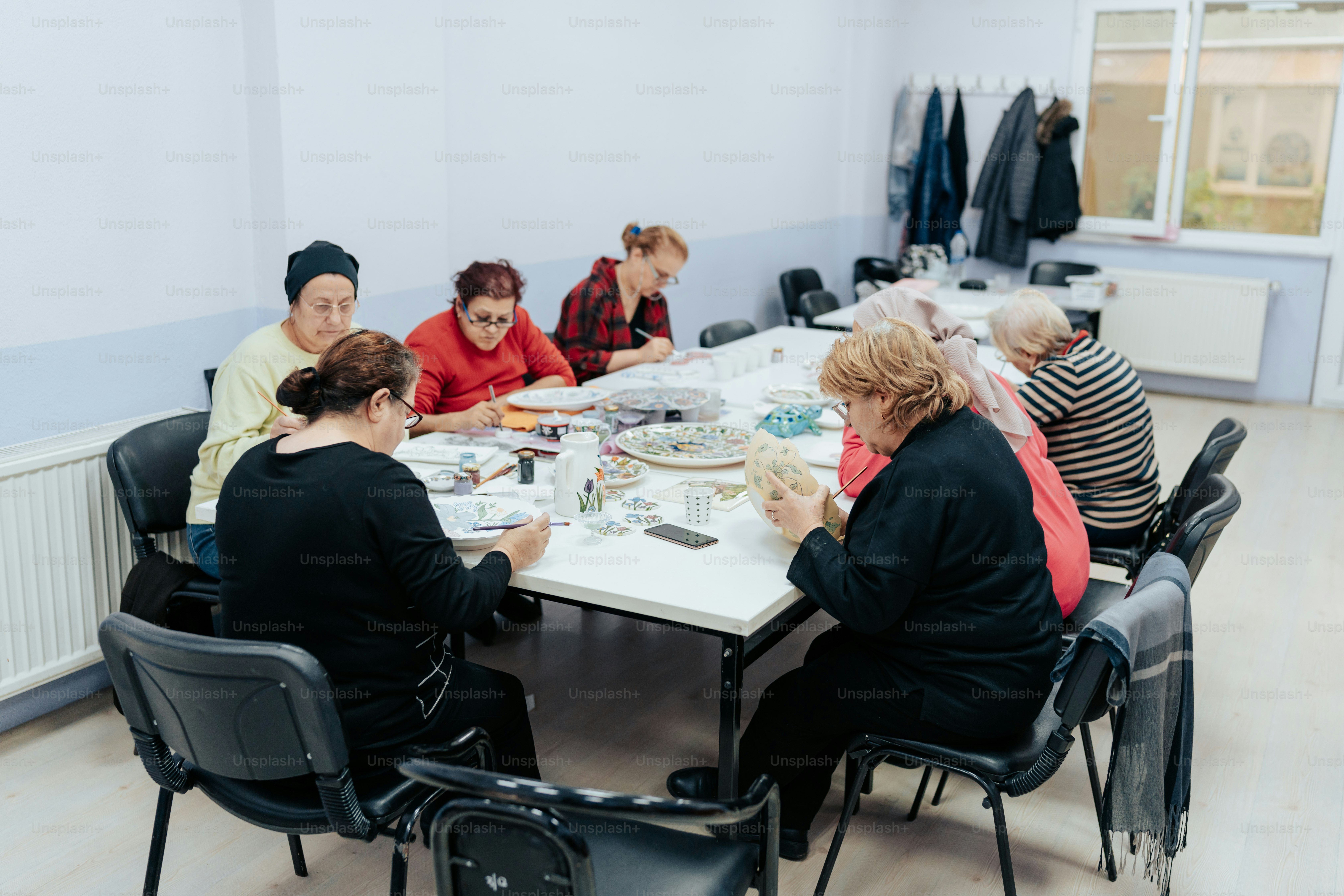 Eine Gruppe von Menschen, die um einen weißen Tisch sitzen