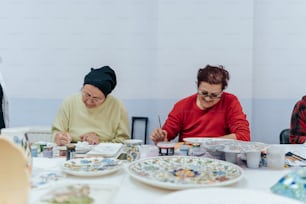 a couple of women sitting at a table with plates