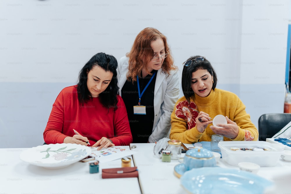 a group of women sitting around a white table