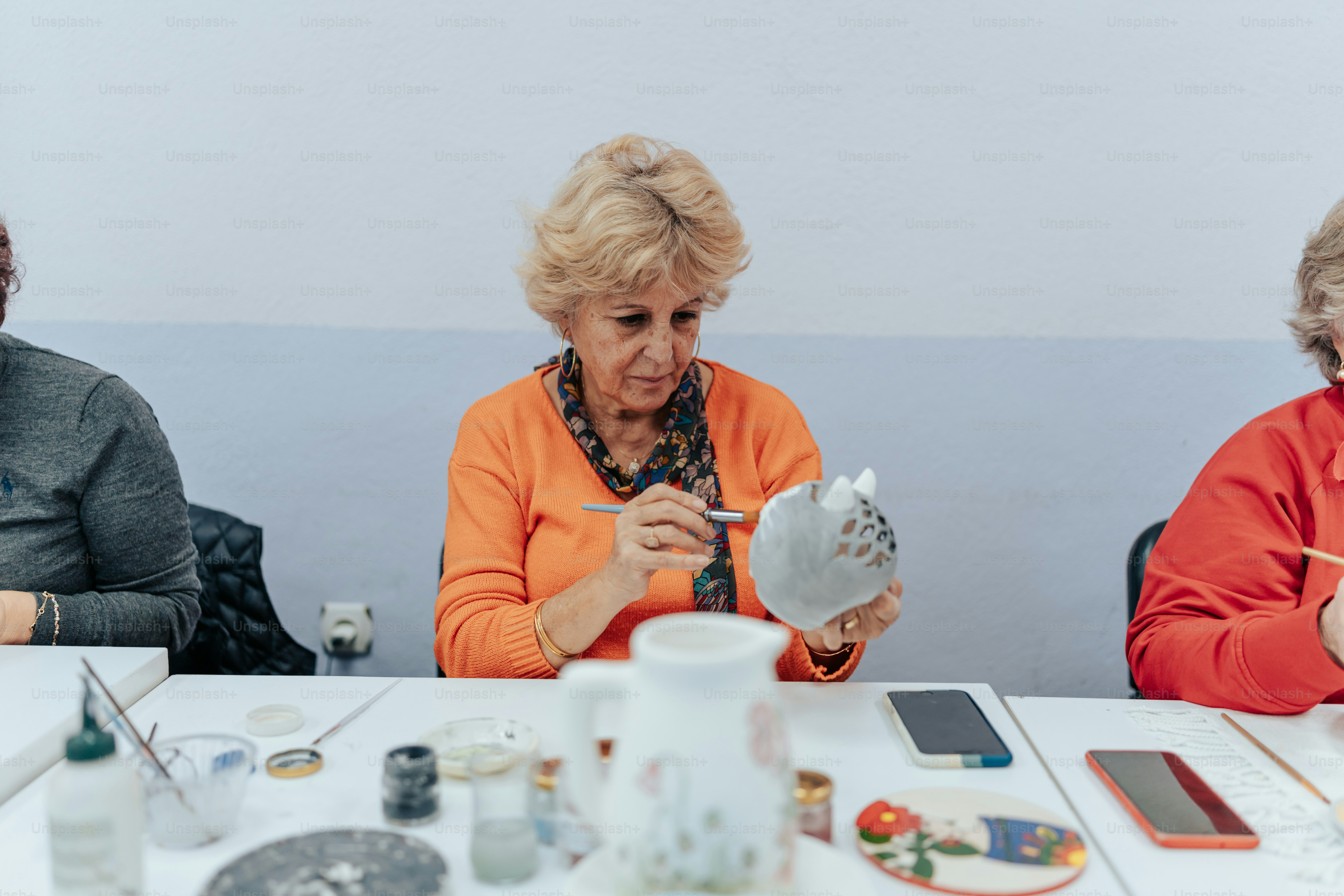 a group of women sitting around a white table