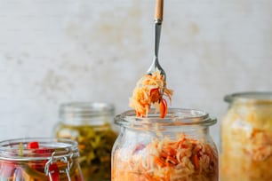 a spoon full of shredded carrots being lifted from a jar