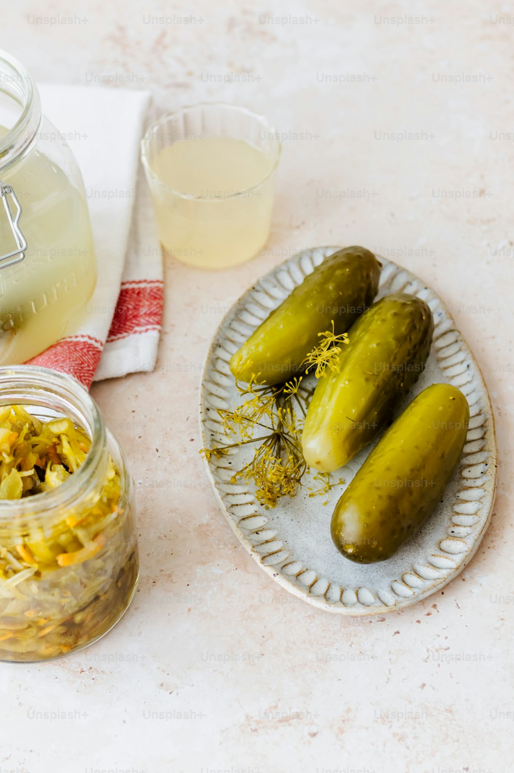 a plate of pickles next to a jar of mustard