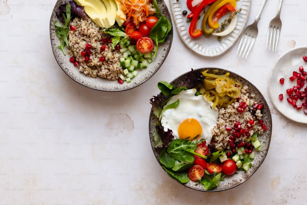 two bowls of food on a table with utensils