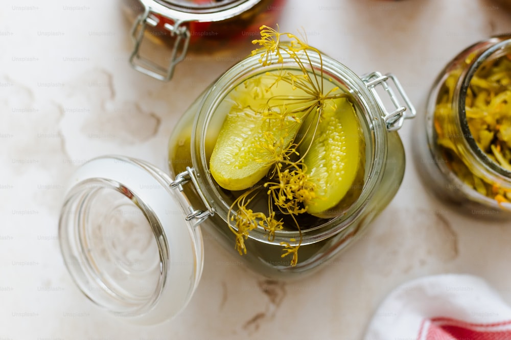 a jar filled with pickles sitting on top of a table