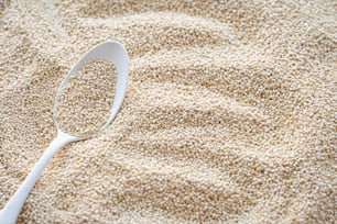 a white spoon sitting on top of a pile of sand