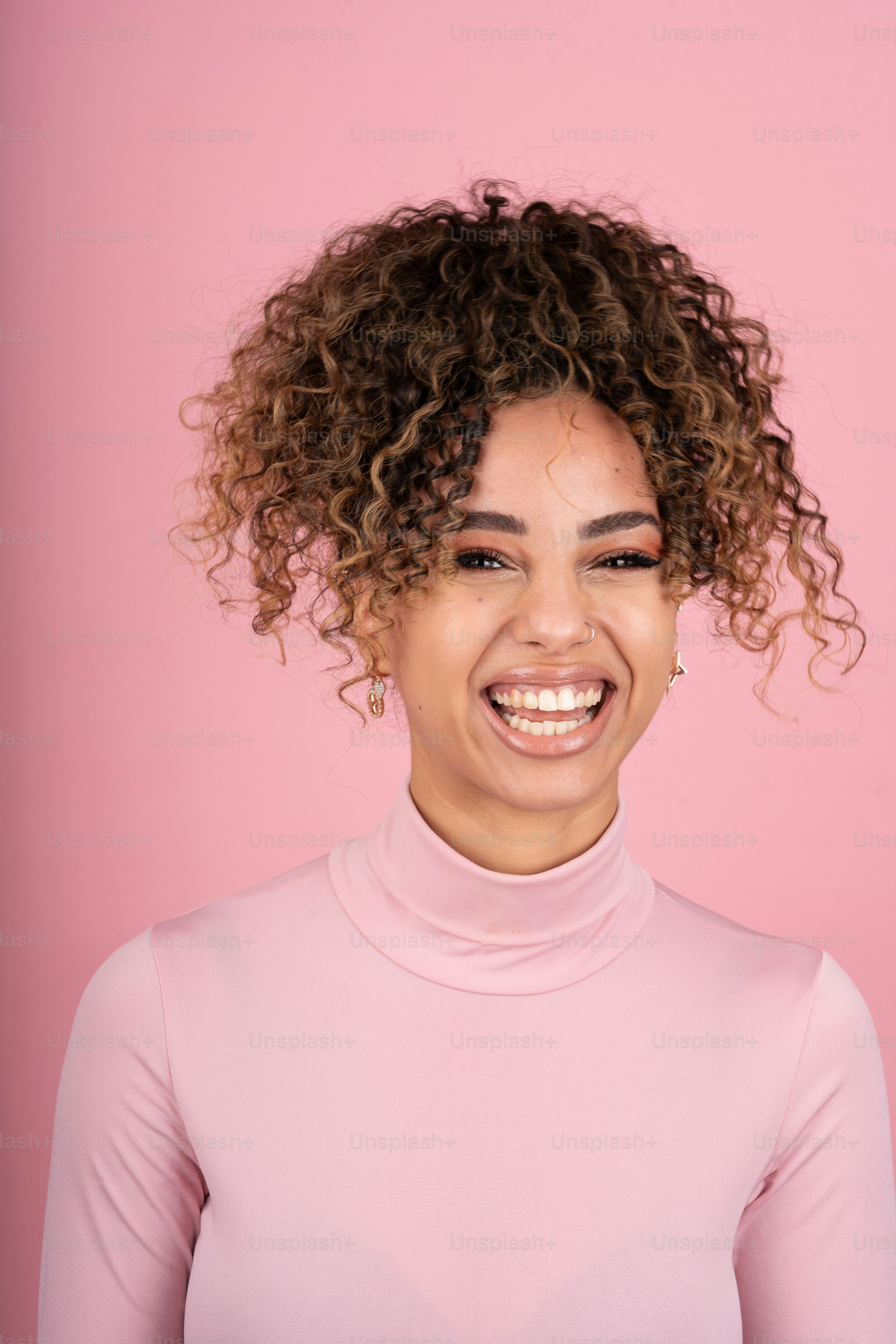 a woman with curly hair smiling at the camera