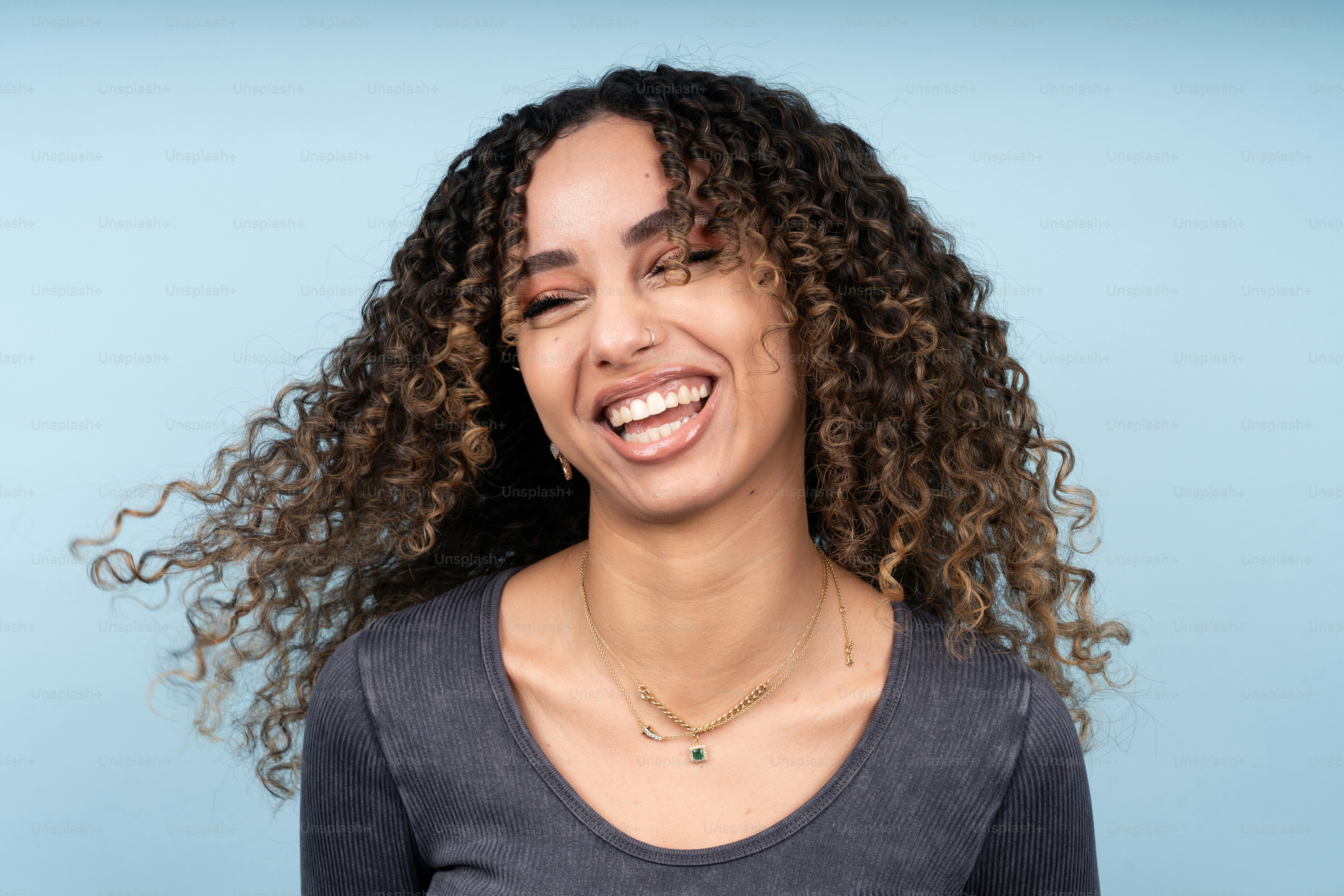 una mujer de pelo rizado sonriendo a la cámara