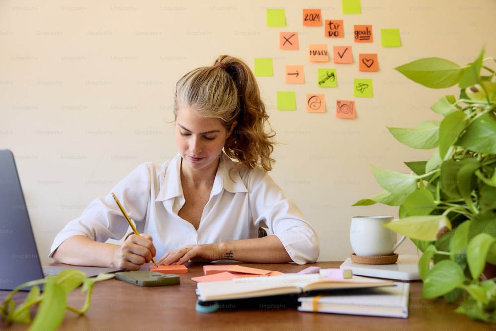 a woman sitting at a desk writing on a piece of paper