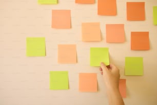 a hand holding a piece of paper over a wall