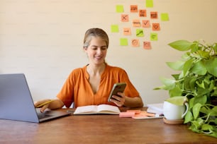 a woman sitting at a table using a cell phone