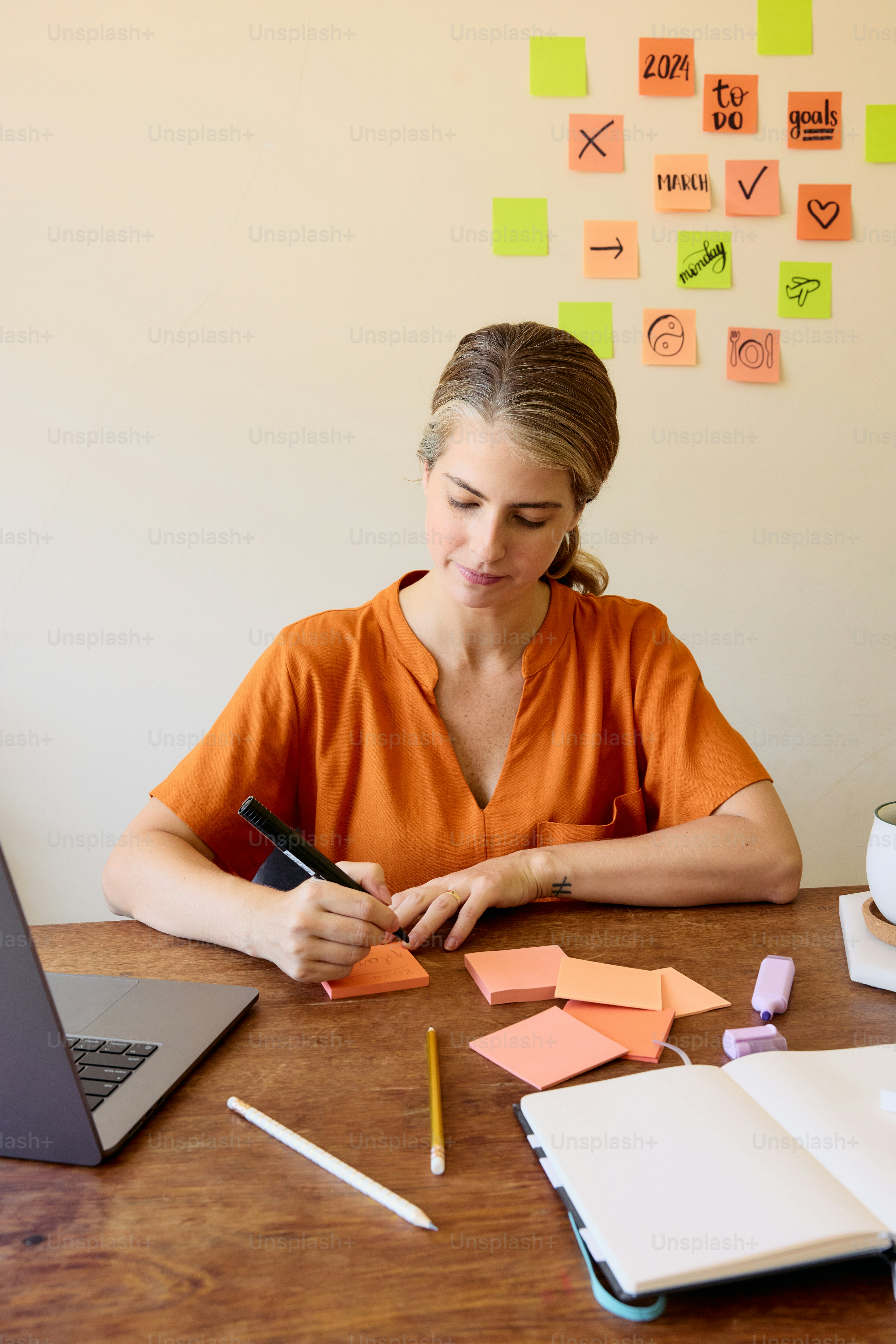 una mujer sentada en una mesa con un cuaderno y un bolígrafo