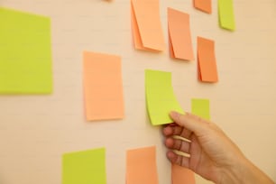 a hand is holding a piece of paper on a wall