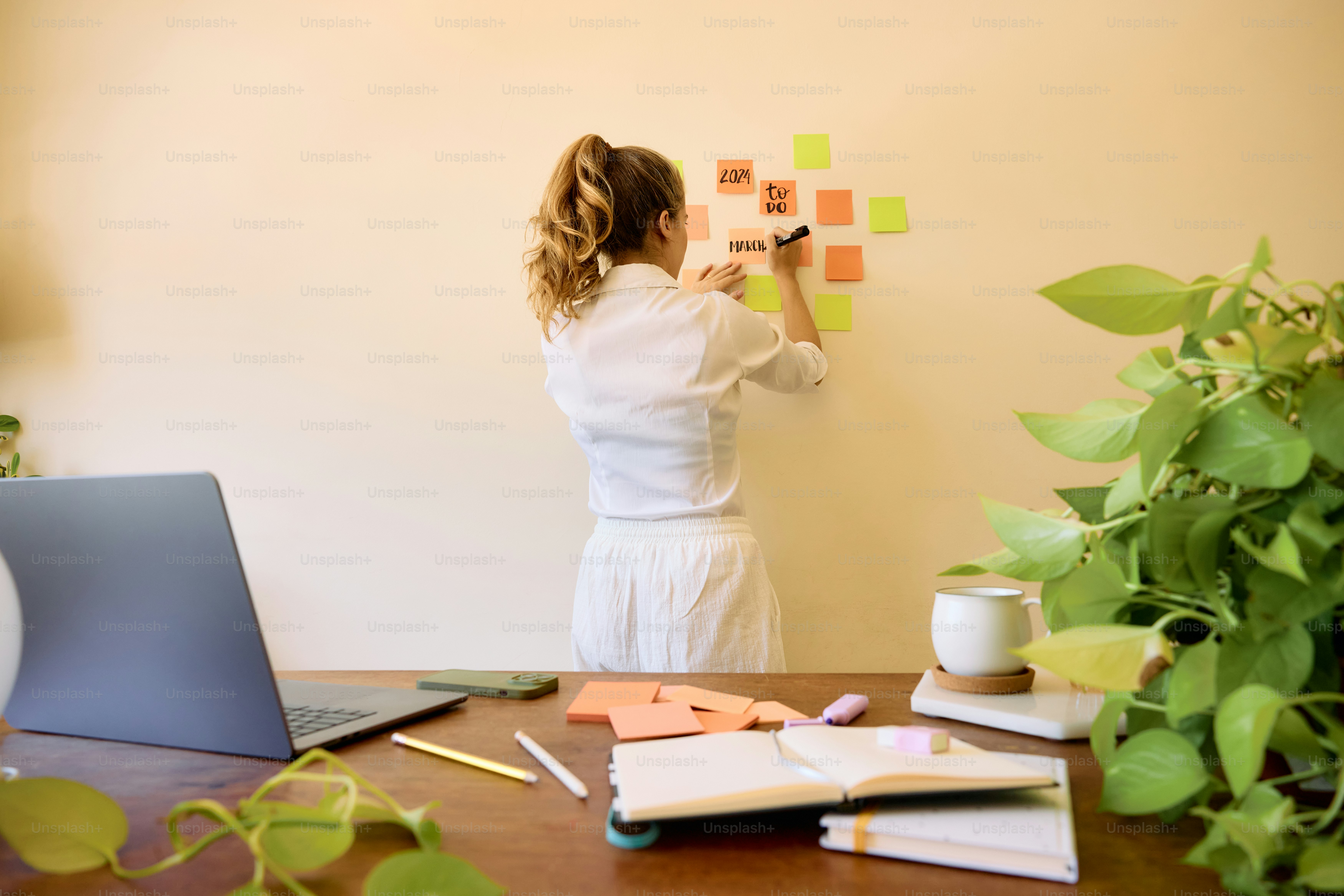eine Frau, die mit Haftnotizen an eine Wand schreibt