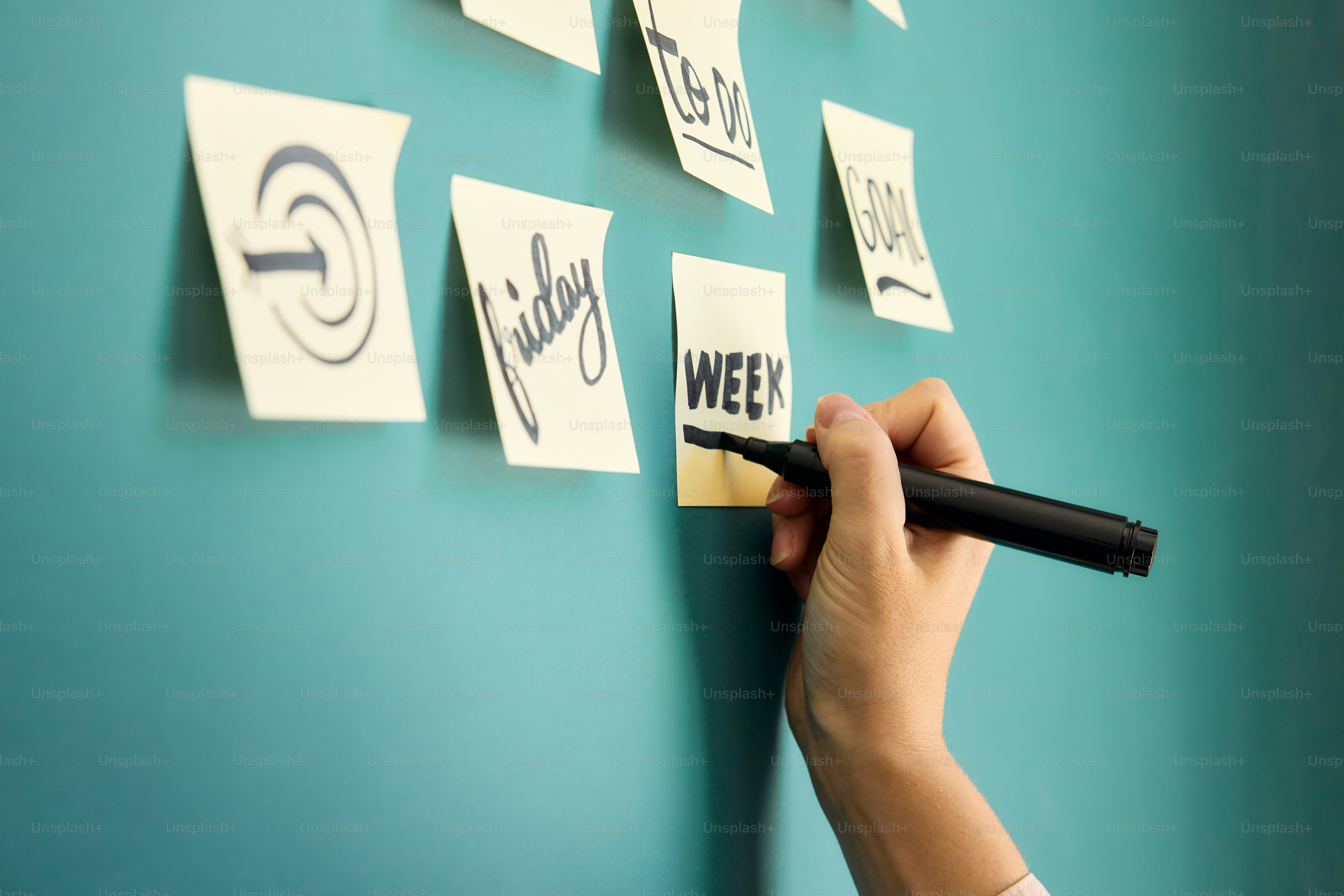 una persona escribiendo en una pared con un rotulador