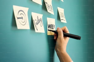 a person writing on a wall with a marker