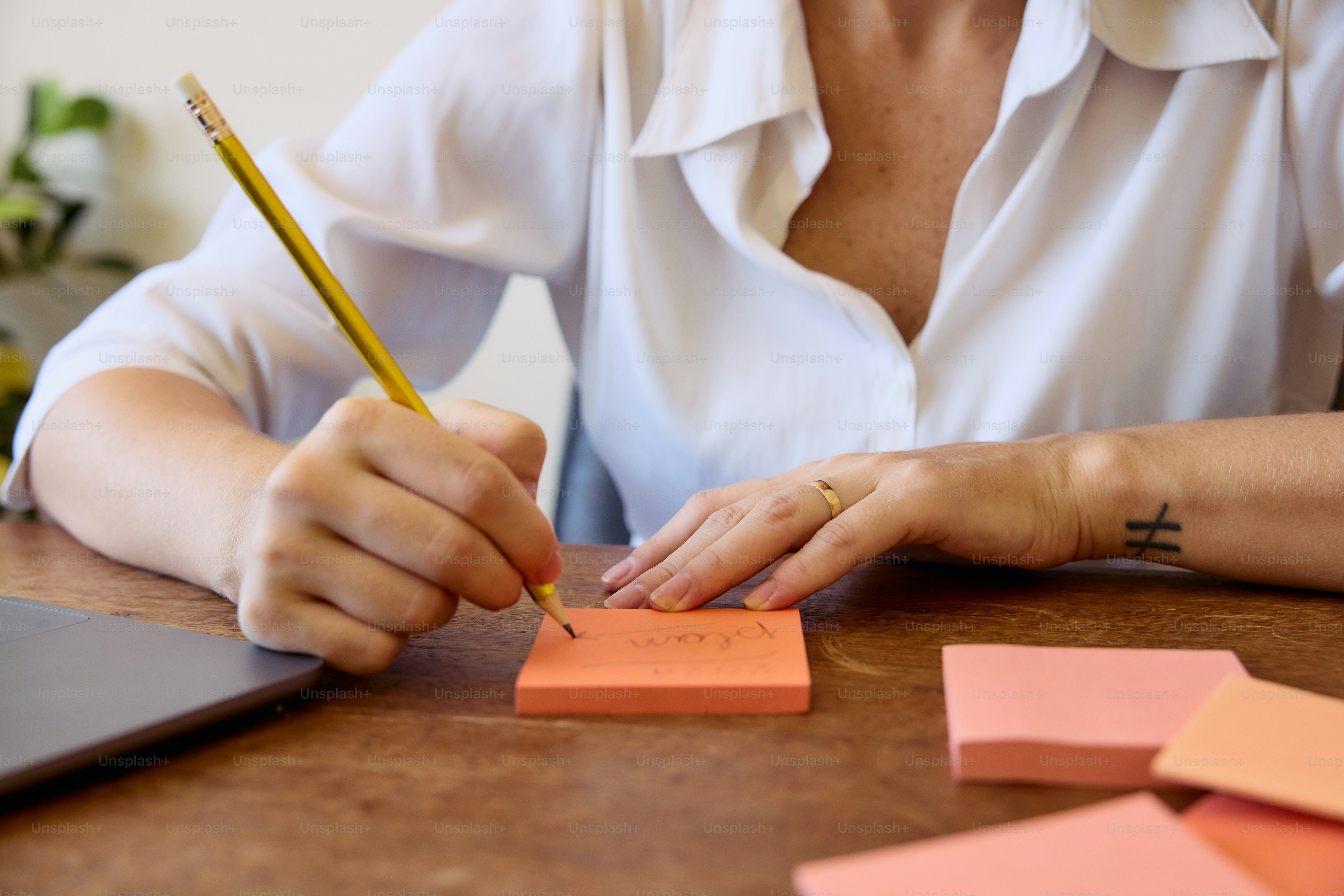 una mujer escribiendo en un pedazo de papel con un lápiz