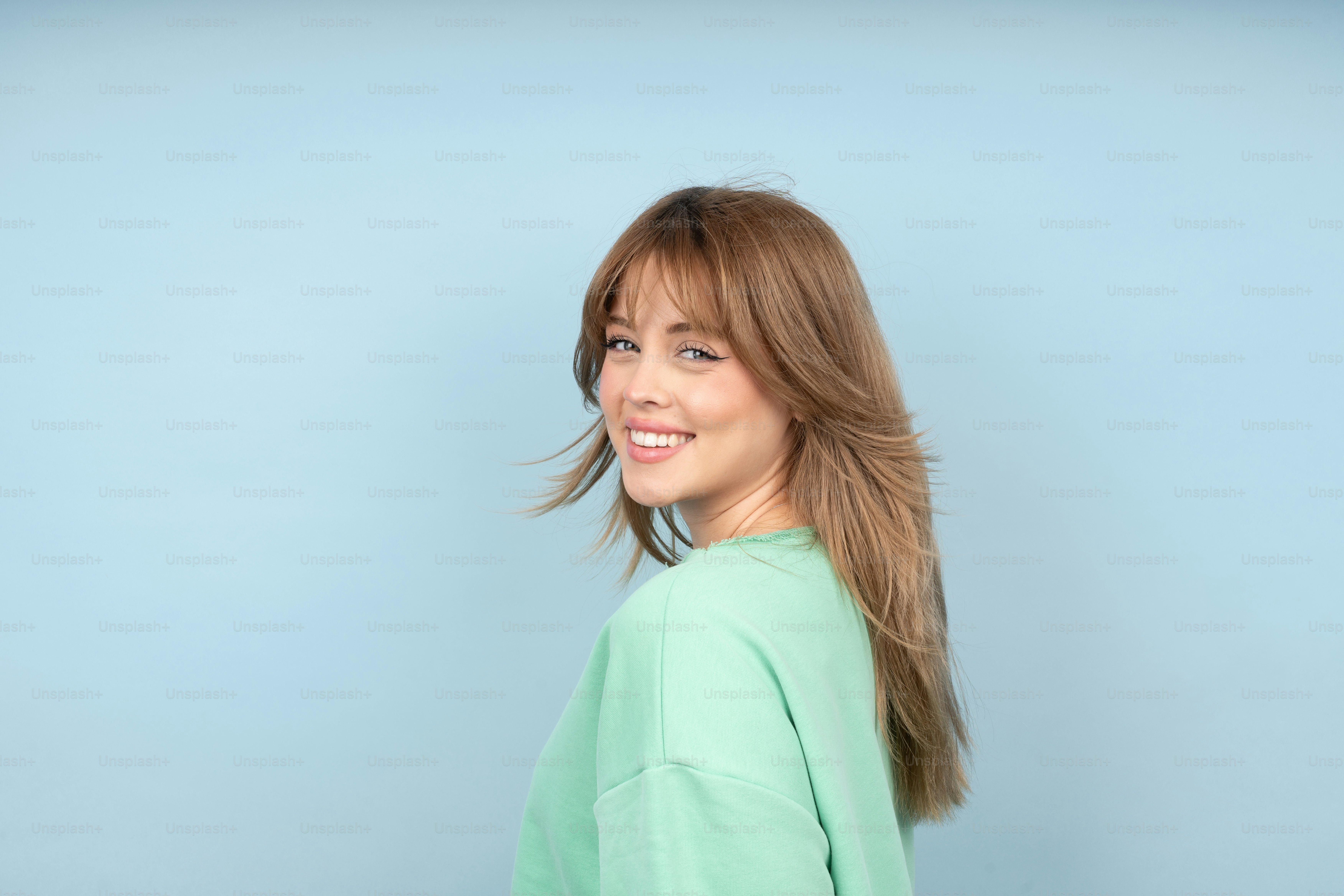 a woman with long hair and a green shirt
