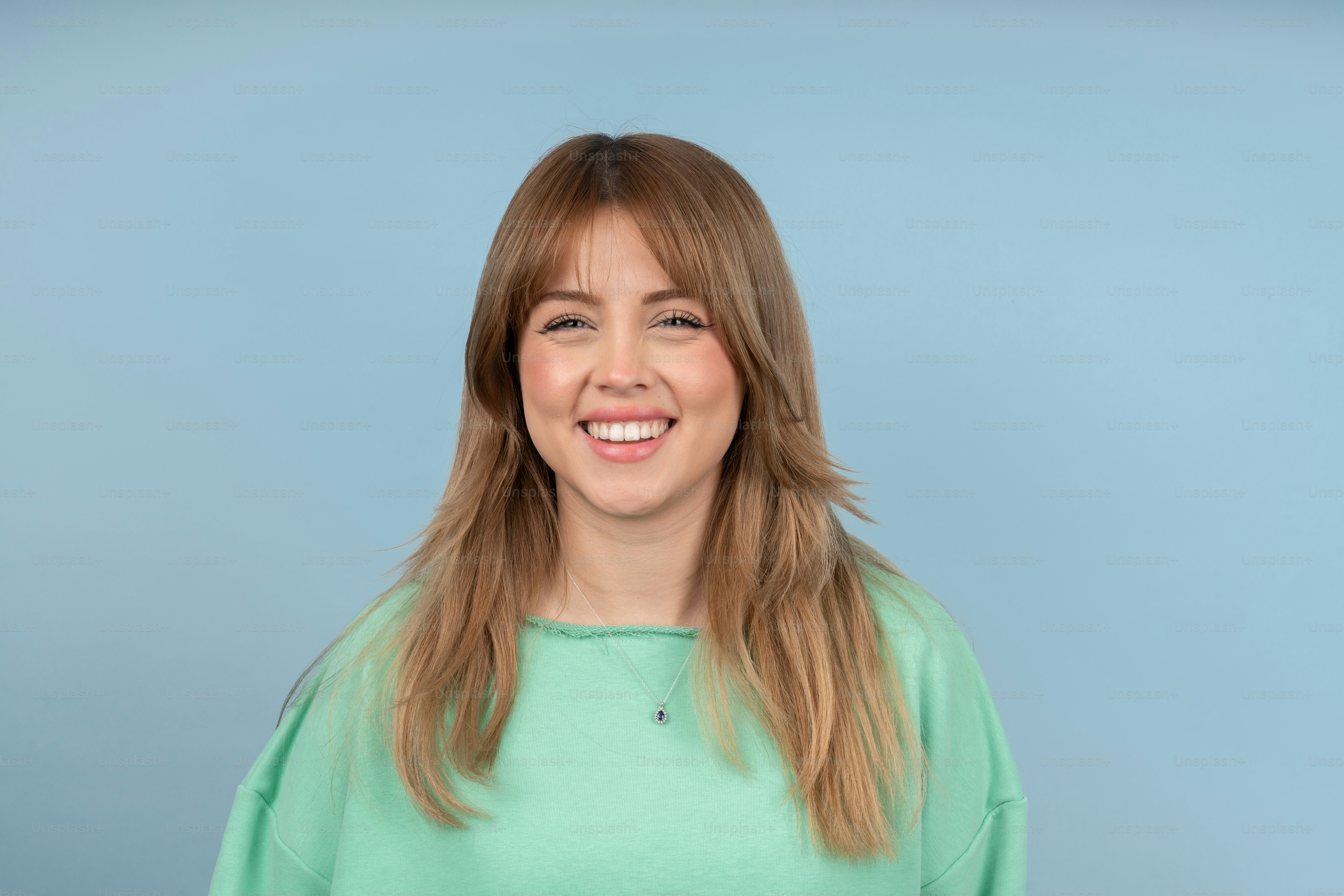a woman in a green shirt smiling at the camera