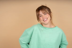 Eine Frau lächelt und trägt ein grünes Sweatshirt