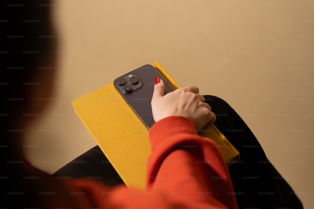 a woman is holding a yellow folder and touching it
