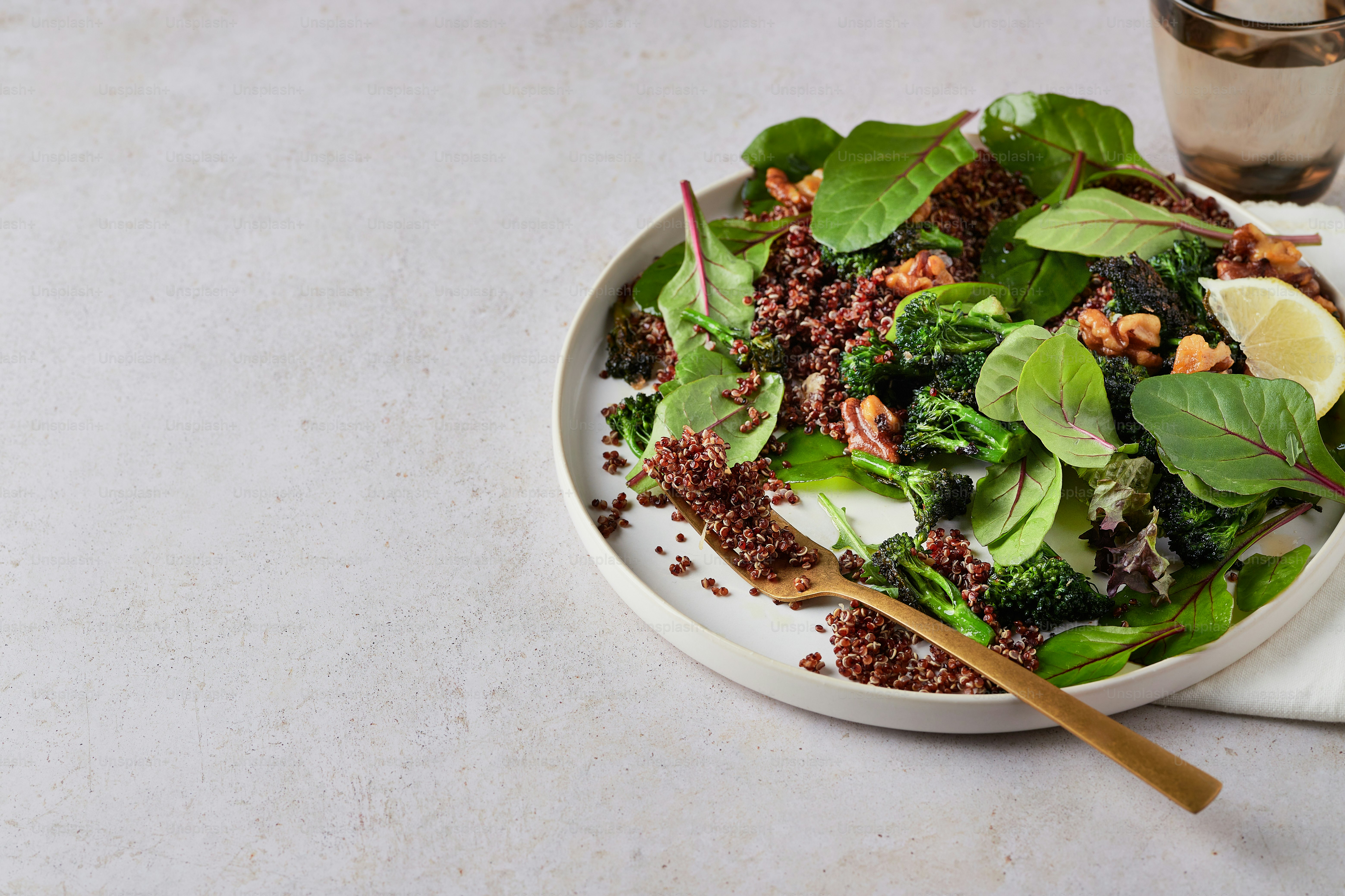 a white plate topped with a salad next to a glass of water