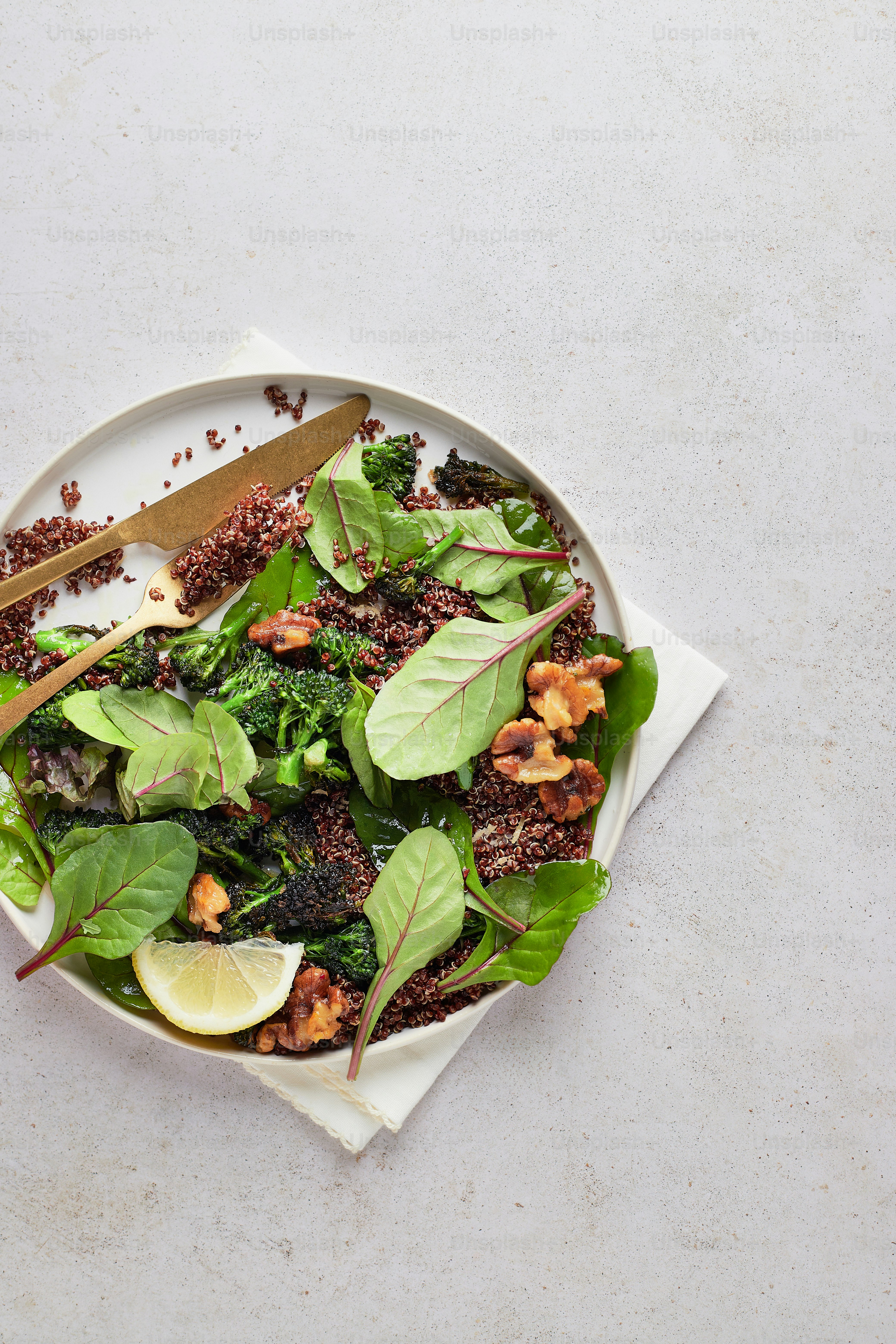 a white plate topped with a salad covered in greens