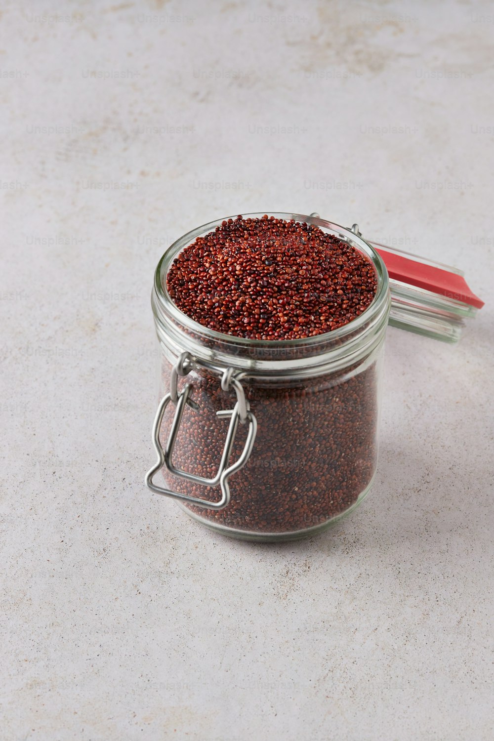 a glass jar filled with red stuff sitting on top of a table