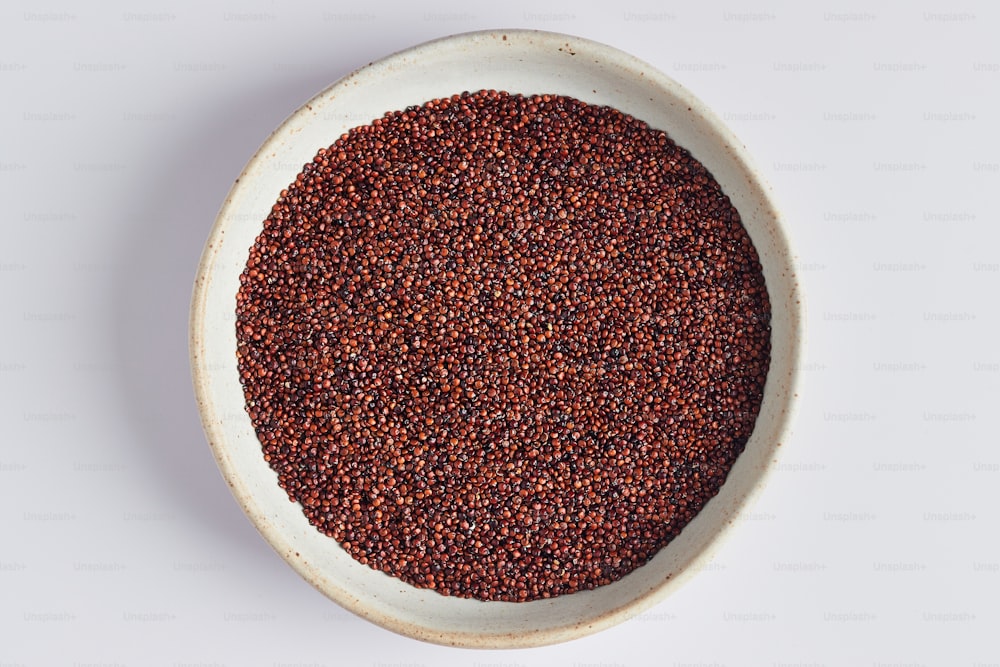 a white bowl filled with red lentils on top of a white table