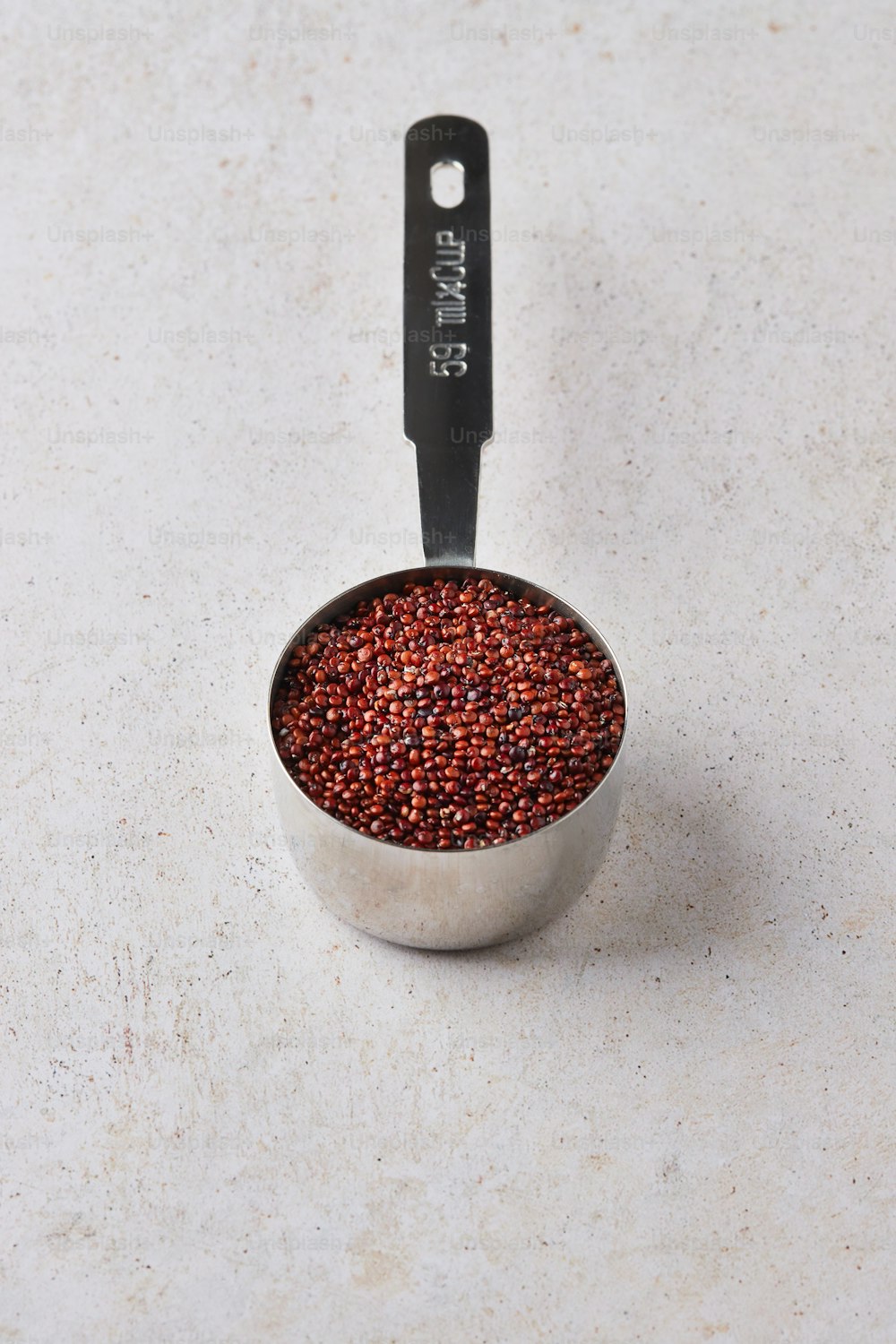 a measuring cup filled with red food on top of a white counter
