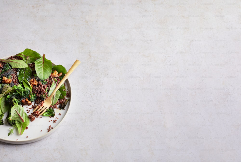 a white plate topped with a green salad