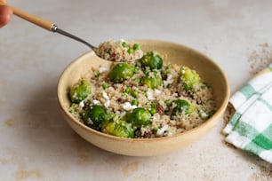 uma tigela cheia de arroz e brócolis em cima de uma mesa