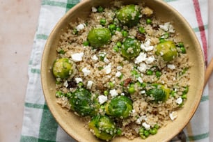a bowl filled with rice, brussel sprouts and cheese