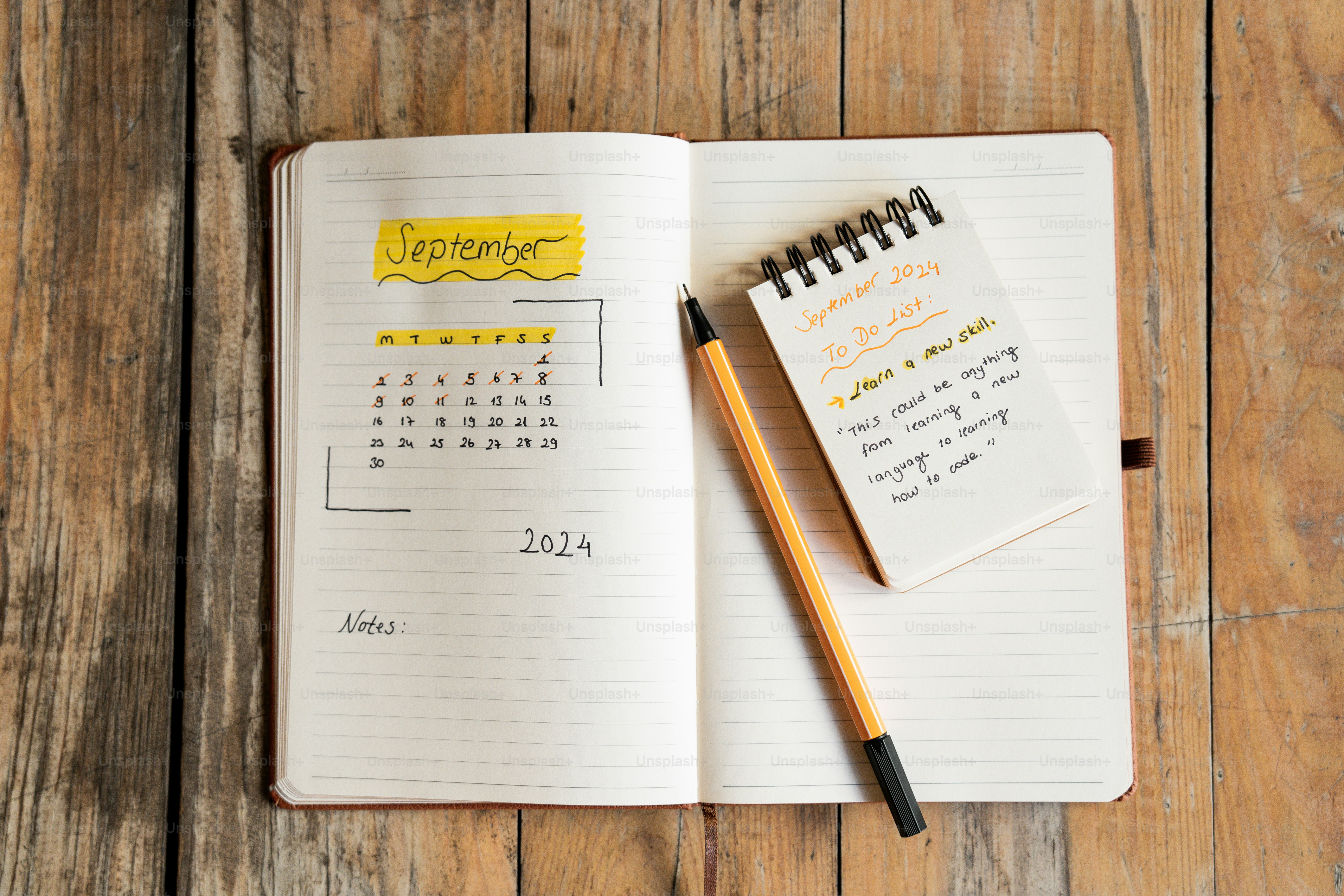 buku catatan dengan kalender dan pena di atasnya