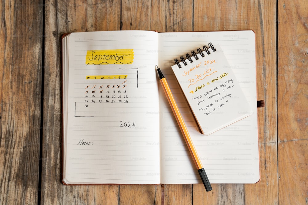 ein Notizbuch mit einem Kalender und einem Stift darauf