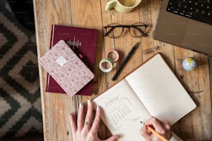 a person sitting at a table with a notebook and pen