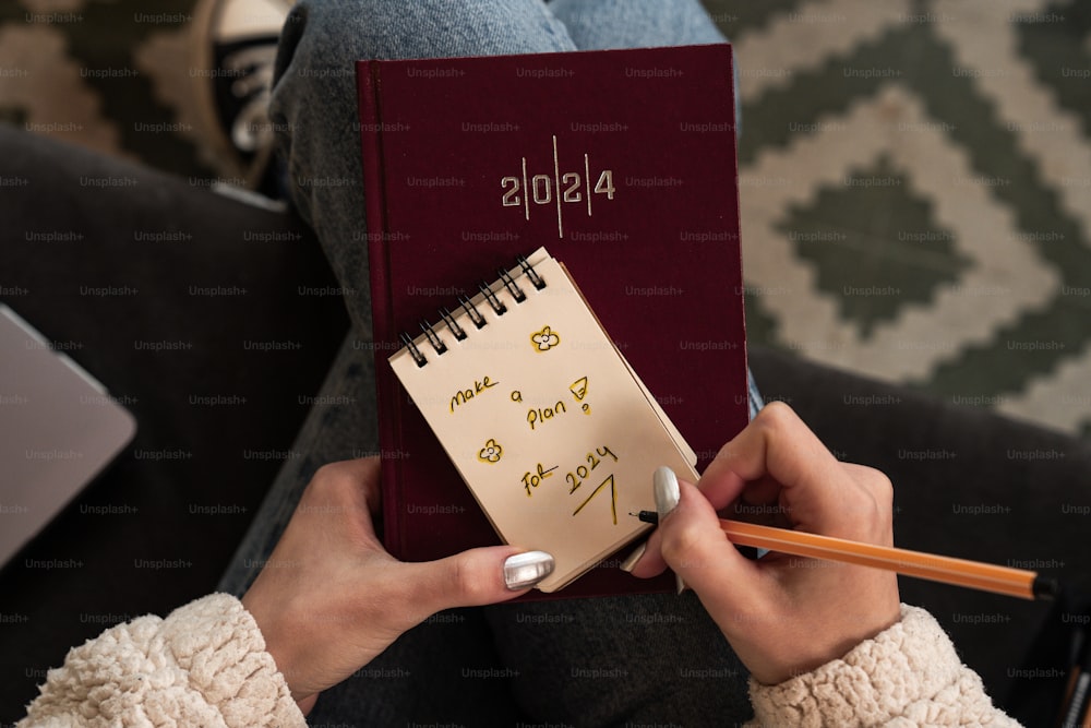 a person holding a notebook with writing on it