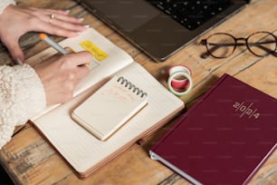 una persona sentada en un escritorio con un cuaderno y un bolígrafo