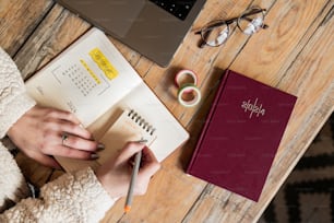 a person sitting at a table with a notebook and pen