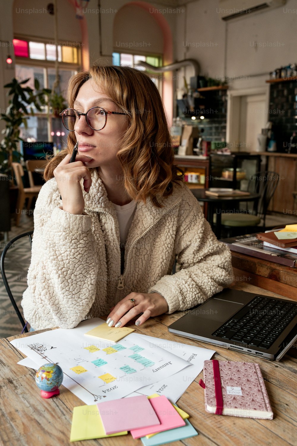 uma mulher sentada em uma mesa com um computador portátil