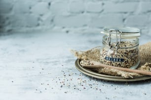 a glass jar filled with bird seed next to a wooden spoon