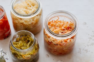 four jars filled with different types of food